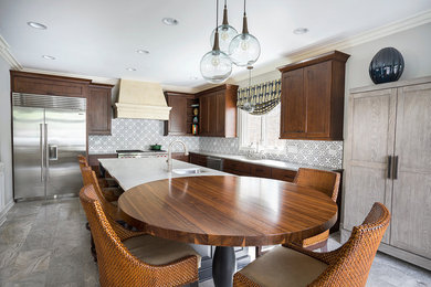 Large transitional l-shaped travertine floor eat-in kitchen photo in Chicago with an undermount sink, recessed-panel cabinets, wood countertops, stainless steel appliances, an island and dark wood cabinets