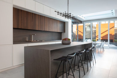 Eat-in kitchen - huge modern u-shaped porcelain tile and gray floor eat-in kitchen idea in New York with an undermount sink, gray backsplash, paneled appliances, an island and gray countertops