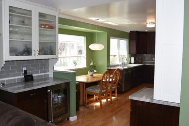 Enclosed kitchen - mid-sized contemporary galley light wood floor enclosed kitchen idea in San Francisco with an undermount sink, brown cabinets, granite countertops, glass tile backsplash, stainless steel appliances, no island, shaker cabinets and gray backsplash