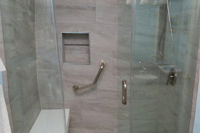 Inspiration for a mid-sized contemporary 3/4 gray tile and porcelain tile bathroom remodel in Toronto with glass-front cabinets and solid surface countertops