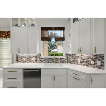 White cabinetry with brass hardware and eye-catching blue pendant lights