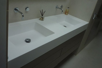 Ejemplo de cuarto de baño moderno de tamaño medio con armarios con paneles lisos, lavabo encastrado y encimeras blancas