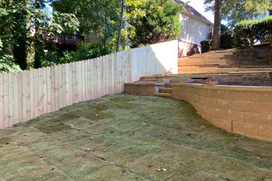 Imagen de jardín minimalista en patio trasero con exposición parcial al sol y con madera