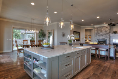 Example of a large transitional medium tone wood floor open concept kitchen design in Seattle with an undermount sink, recessed-panel cabinets, gray cabinets, quartz countertops and an island