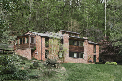 Mid-sized contemporary two-story brick house exterior idea in Other