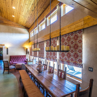 Inredning av ett amerikanskt mellanstort kök med matplats, med beige väggar, betonggolv, en öppen vedspis, en spiselkrans i betong och grönt golv