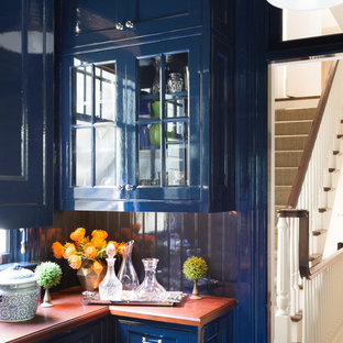 Exemple d'une arrière-cuisine chic en U de taille moyenne avec un placard à porte vitrée, des portes de placard bleues, une crédence bleue, un sol en bois brun, aucun îlot et un évier posé.