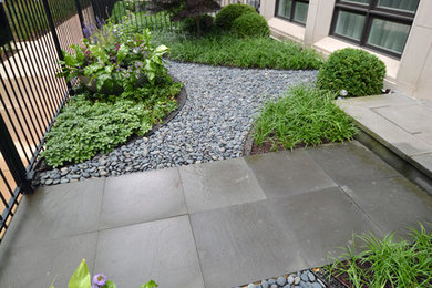 This is an example of a mid-sized modern front yard partial sun formal garden in Chicago with a garden path and natural stone pavers.