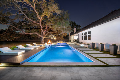 Idee per una grande piscina stile shabby rettangolare dietro casa con pavimentazioni in pietra naturale