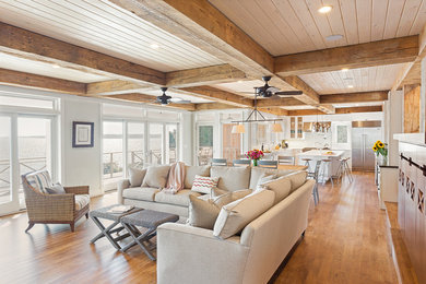 Living room - large coastal open concept light wood floor living room idea in New York with a standard fireplace, gray walls and no tv