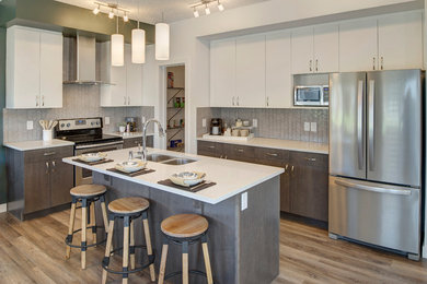 Inspiration for a mid-sized transitional l-shaped vinyl floor and brown floor eat-in kitchen remodel in Edmonton with an undermount sink, flat-panel cabinets, white cabinets, quartzite countertops, gray backsplash, porcelain backsplash, stainless steel appliances and white countertops