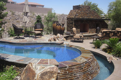 Mid-sized mountain style backyard custom-shaped natural pool fountain photo in Denver with decking
