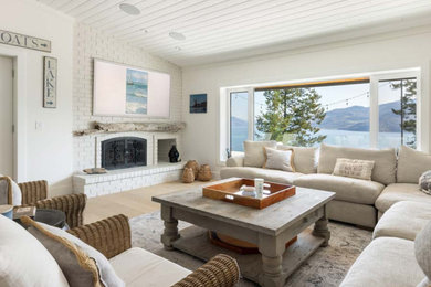 Inspiration for a large cottage open concept light wood floor, brown floor and wood ceiling family room remodel in Vancouver with white walls, a standard fireplace, a brick fireplace and a wall-mounted tv