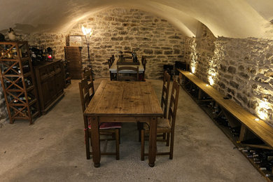 Idée de décoration pour une grande cave à vin champêtre avec sol en béton ciré, des casiers losange et un sol gris.