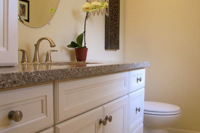 Bathroom - traditional gray tile and stone slab bathroom idea in Calgary with an undermount sink, a one-piece toilet, raised-panel cabinets, white cabinets and quartz countertops