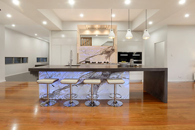 This is an example of a contemporary kitchen in Brisbane with concrete benchtops and with island.