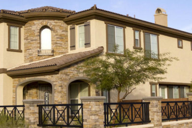 Large traditional brown two-story stucco house exterior idea in Tampa