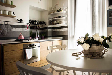 Idee per una piccola cucina lineare eclettica con lavello sottopiano, ante in legno chiaro, top in quarzite, paraspruzzi bianco, paraspruzzi in lastra di pietra, elettrodomestici in acciaio inossidabile, pavimento con piastrelle in ceramica, nessuna isola, pavimento nero e top bianco