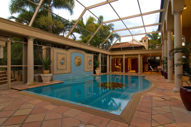 Modern indoor pool in Brisbane with a pool house and brick pavers.
