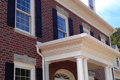 Large elegant red brick exterior home photo in Other
