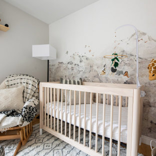 Small eclectic gender-neutral light wood floor and wallpaper nursery photo in Denver with beige walls