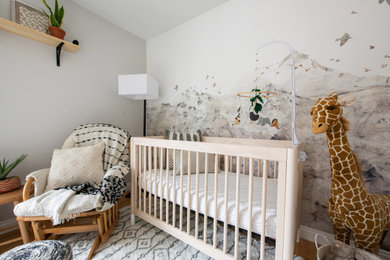 Small eclectic gender-neutral light wood floor and wallpaper nursery photo in Denver with beige walls