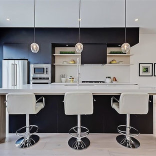 Inredning av ett modernt mellanstort linjärt skafferi, med en undermonterad diskho, släta luckor, svarta skåp, bänkskiva i onyx, stänkskydd i keramik, rostfria vitvaror, terrazzogolv, en köksö och vitt golv