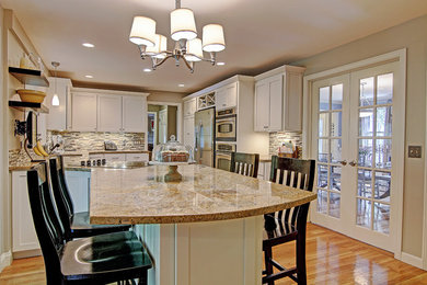 Mid-sized transitional u-shaped light wood floor eat-in kitchen photo in Providence with an undermount sink, shaker cabinets, white cabinets, granite countertops, multicolored backsplash, matchstick tile backsplash, stainless steel appliances and a peninsula