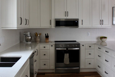 Eat-in kitchen - mid-sized transitional u-shaped medium tone wood floor eat-in kitchen idea in Edmonton with an undermount sink, shaker cabinets, white cabinets, quartz countertops, white backsplash, porcelain backsplash, stainless steel appliances, a peninsula and white countertops