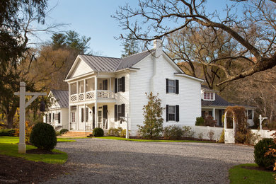 Example of a cottage white exterior home design with a metal roof