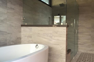 Photo of a large transitional master bathroom in Los Angeles with flat-panel cabinets, black cabinets, a freestanding tub, a corner shower, beige tile, porcelain tile, beige walls, a vessel sink, solid surface benchtops, multi-coloured floor and a hinged shower door.