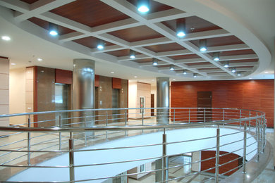 На фото: большой коридор в современном стиле с коричневыми стенами, мраморным полом и бежевым полом