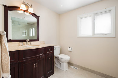 Inspiration for a timeless beige tile and porcelain tile porcelain tile and beige floor doorless shower remodel in Toronto with brown cabinets, beige walls, granite countertops and beige countertops