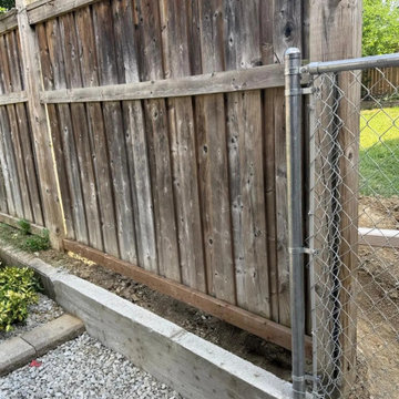 New chain link and concrete base meeting the existing wood fence at the rear, Mi
