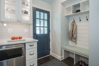 Inspiration for a mid-sized coastal galley dark wood floor and gray floor eat-in kitchen remodel in Milwaukee with an undermount sink, shaker cabinets, white cabinets, quartz countertops, blue backsplash, limestone backsplash, stainless steel appliances, a peninsula and white countertops