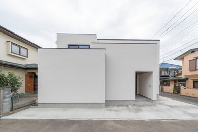 Inspiration for a mid-sized modern two-story stucco exterior home remodel in Tokyo Suburbs with a shed roof, a metal roof and a black roof