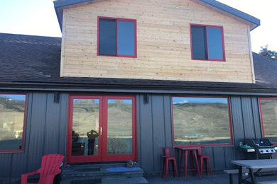 Example of a mid-sized mountain style green two-story mixed siding exterior home design in Denver with a shingle roof