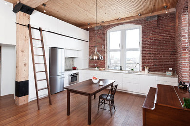 Inspiration for a large contemporary medium tone wood floor and brown floor eat-in kitchen remodel in Montreal with stainless steel appliances, an undermount sink, flat-panel cabinets, white cabinets, no island, brown backsplash and brick backsplash