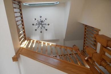 Photo of a large classic foyer in Other with white walls, brown floors and feature lighting.