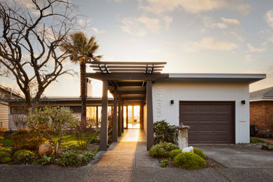 Imagen de fachada de casa gris vintage de tamaño medio de una planta con revestimiento de madera y tejado plano