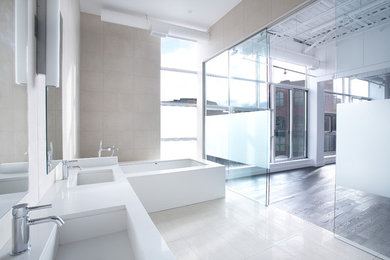 This is an example of a large contemporary master bathroom in Toronto with white cabinets, an undermount tub, beige tile, stone tile, beige walls, ceramic floors, an undermount sink, engineered quartz benchtops and beige floor.