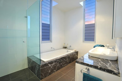 This is an example of a mid-sized contemporary bathroom in Melbourne with a drop-in tub, a corner shower, white tile, ceramic tile, porcelain floors, brown floor and a hinged shower door.