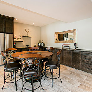 This is an example of a farmhouse walk-out basement in Toronto with grey walls, travertine flooring, a standard fireplace, a stone fireplace surround and grey floors.