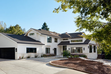 Huge transitional white two-story stucco exterior home photo in San Francisco with a shingle roof and a black roof