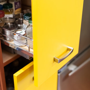 Zweizeilige, Kleine Stilmix Küche ohne Insel mit Vorratsschrank, Unterbauwaschbecken, flächenbündigen Schrankfronten, gelben Schränken, Granit-Arbeitsplatte, bunter Rückwand, Rückwand aus Keramikfliesen, Küchengeräten aus Edelstahl und braunem Holzboden in Portland