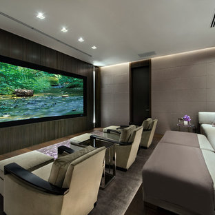 Example of a large trendy open concept dark wood floor and brown floor home theater design in Miami with gray walls and a projector screen