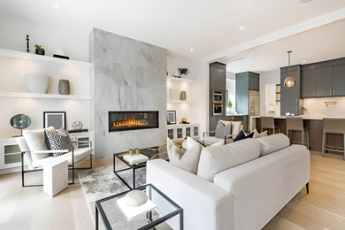 Large open concept light wood floor and gray floor living room photo with white walls, a standard fireplace, a tile fireplace and a concealed tv