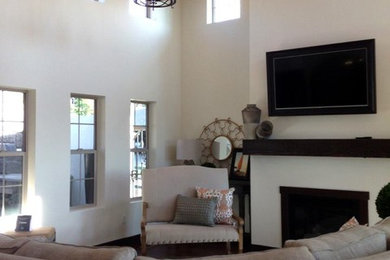 Example of a mid-sized transitional open concept dark wood floor and brown floor living room design in Denver with white walls, a standard fireplace and a wall-mounted tv