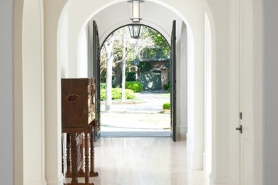 Design ideas for a mediterranean entry hall in Dallas with white walls and beige floor.