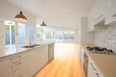 Photo of a contemporary kitchen in Adelaide with white splashback and with island.